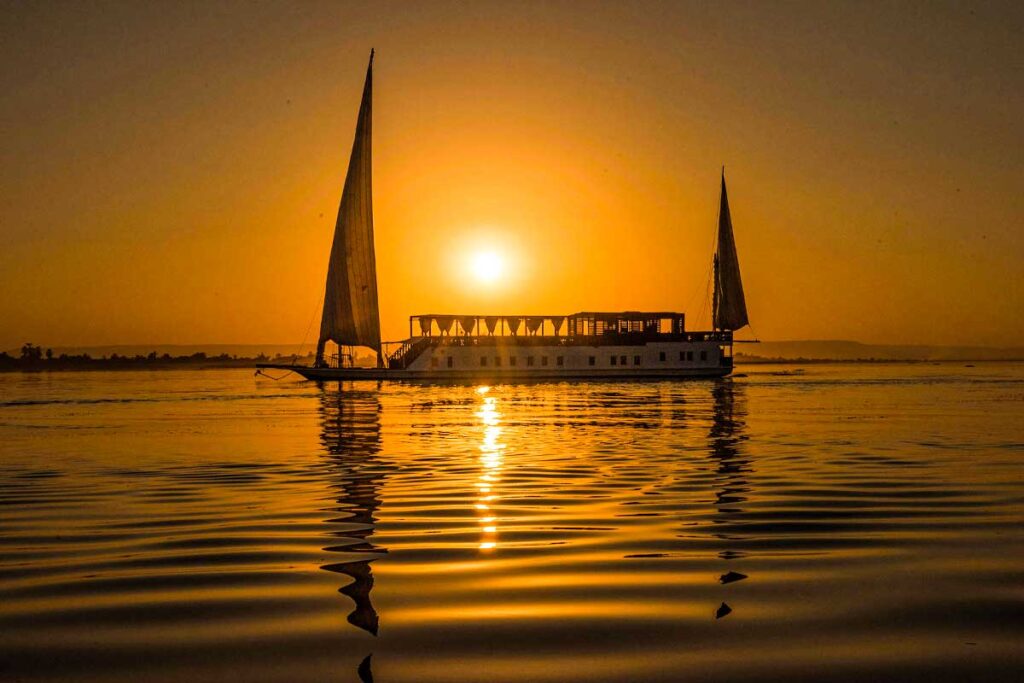 Jak rozpoznać dobrą organizację wycieczek w Egipcie jeszcze przed rezerwacją 4 A wonderful view of the Dahabiya boat in the Nile River and the sunset appears from behind it